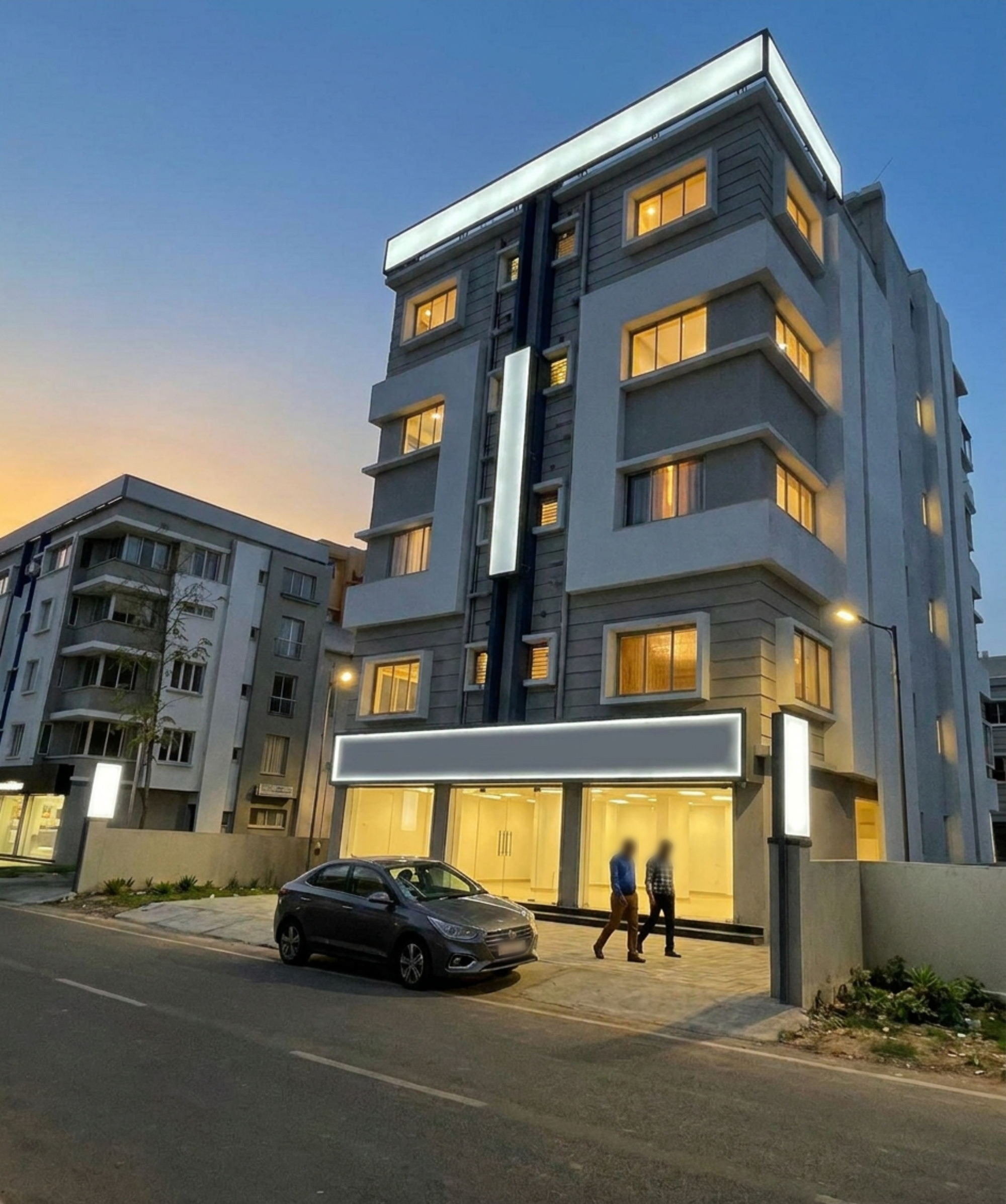 362 Barkhola, Mukundapur at dusk: a completed five-storey commercial building with lit upper floors and three glazed retail units at street level